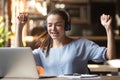 Excited woman wearing headset enjoying music, using laptop in cafe Royalty Free Stock Photo