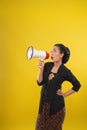 Excited woman wearing traditional Javanese clothes talk using megaphone