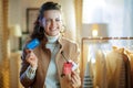 Woman trying coat with sale price tag and holding credit card Royalty Free Stock Photo