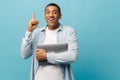 Excited young african-american male student in casual shirt stands with laptop pc hold index finger up with great new Royalty Free Stock Photo
