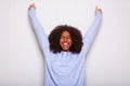 Excited young african american woman cheering with hands raised against white background Royalty Free Stock Photo