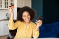 Young African-American woman using smartphone for shopping online Royalty Free Stock Photo