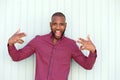 Excited young african man gesturing rock and roll sign by wall Royalty Free Stock Photo