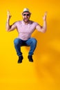 Excited young bearded fitness sporty guy in hat and sunglasses Jump very emotionally isolated on yellow background