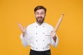 Excited young bearded male chef cook or baker man in white uniform shirt posing isolated on yellow background. Cooking Royalty Free Stock Photo