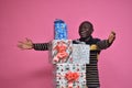 excited young black man feeling excited stretching his arms around a stack of gifts Royalty Free Stock Photo