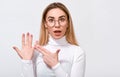 Excited young blonde woman wearing white blouse and round trendy transparent glasses, showing engagement ring on her finger Royalty Free Stock Photo