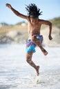 Splash. An excited young boy leaping into the air while at the beach. Royalty Free Stock Photo