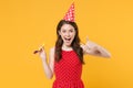 Excited young brunette woman girl in red summer dress, birthday hat posing isolated on yellow wall background studio Royalty Free Stock Photo