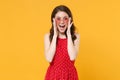 Excited young brunette woman girl in red summer dress, eyeglasses posing isolated on yellow wall background studio Royalty Free Stock Photo