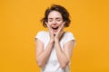 Excited young brunette woman girl in white t-shirt posing isolated on yellow orange background studio portrait. People Royalty Free Stock Photo