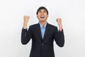 Excited young business Asian man raising his fists with happy delighted face, celebrating success isolated on white background. Royalty Free Stock Photo