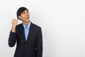 Excited young business Asian man raising his fists with happy delighted face, celebrating success isolated on white background. Royalty Free Stock Photo