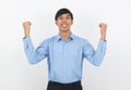 Excited young business Asian man raising his fists with happy delighted face, celebrating success isolated on white background. Royalty Free Stock Photo