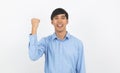 Excited young business Asian man raising his fists with happy delighted face, celebrating success isolated on white background. Royalty Free Stock Photo