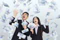 Excited young business man and woman with dollars under money rain Royalty Free Stock Photo