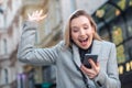 Excited young business woman looking to her phone on the street Royalty Free Stock Photo