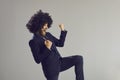 Excited young businessman with crazy funny hairstyle dancing on gray studio background Royalty Free Stock Photo