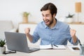 Excited Young Businessman At Laptop Computer Shaking Fists In Office Royalty Free Stock Photo