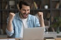 Excited young businessman working from home raise fists shout yeah Royalty Free Stock Photo