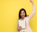 Excited young businesswoman holding fist in the air