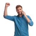 Excited young casual man celebrating good news on the phone Royalty Free Stock Photo