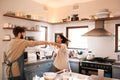 Excited young couple, dance and kitchen in home with love, comic moment and cooking together with romance. Man, woman