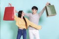 Excited young couple holding shopping bags. Looking at each other.Isolated on blue background Royalty Free Stock Photo