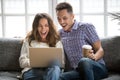 Excited young couple looking at laptop sitting at home sofa Royalty Free Stock Photo