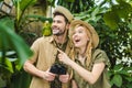 excited young couple in safari suits with parrot