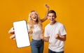 Excited Young Couple Showing Big Smartphone With White Screen And Celebrating Success Royalty Free Stock Photo