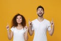 Excited young couple two friends european guy african american girl in white t-shirts isolated on yellow background in Royalty Free Stock Photo