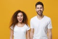 Excited young couple two friends european guy african american girl in white t-shirts posing isolated on yellow Royalty Free Stock Photo