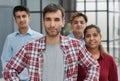 A group of business workers look seriously and confidently at the camera.