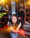 Excited young female aiming laser gun at other players during la Royalty Free Stock Photo