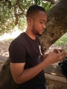 excited young handsome african boy operating his cell phone Royalty Free Stock Photo