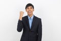 Excited young handsome asian business man raising his fists with smiling