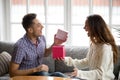 Excited young man opening gift box receiving present from wife Royalty Free Stock Photo