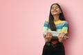 Excited young indian asian girl student posing islolated holding textbooks with love fond of reading or spend free time with books