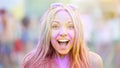 Excited young lady covered in Holi colors smiling camera, having fun at festival