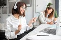 Excited young lady office worker in headphones enjoying music and imagining playing the drums while working in office Royalty Free Stock Photo