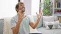 Excited young man celebrating mad, crazy success on the sofa! arms raised in jubilant victory, totally demented with joy. indoor