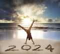 Excited Young man handstand on the beach.happy new year 2024 concept Royalty Free Stock Photo