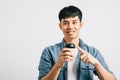 An excited young man holds a takeaway coffee cup, pointing with optimism Royalty Free Stock Photo