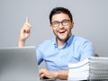 Excited young man with laptop pointing finger up Royalty Free Stock Photo