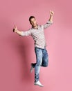 Excited young man in popular shirt jumping celebrating success pointing fingers thumbs up Royalty Free Stock Photo