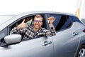 Excited young man showing a car key, sitting inside his new vehicle Royalty Free Stock Photo