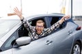 Excited young man showing a car key, sitting inside his new vehicle Royalty Free Stock Photo