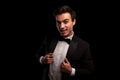 Excited young man wearing tuxedo and holding his collar Royalty Free Stock Photo