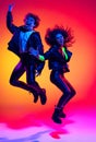 Excited young man and girl in black leather outfits having fun, gesturing, shouting and jumping on yellow-red background Royalty Free Stock Photo